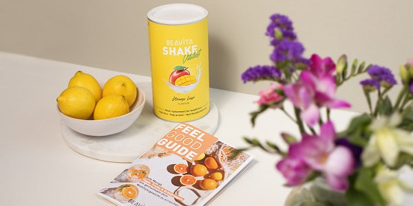 BEAVITA Feel Good Guide und Shake Mango Lassi liegen auf einem Tisch