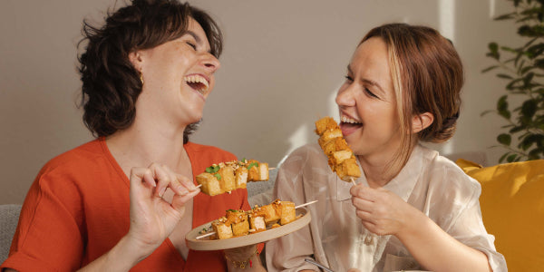 2 Frauen, die Tofu-Spieße essen