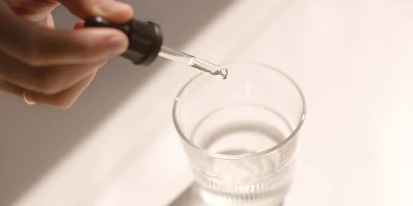 veganes Vitamin D3 einnehmen - Pipette Tropfen Glas Wasser