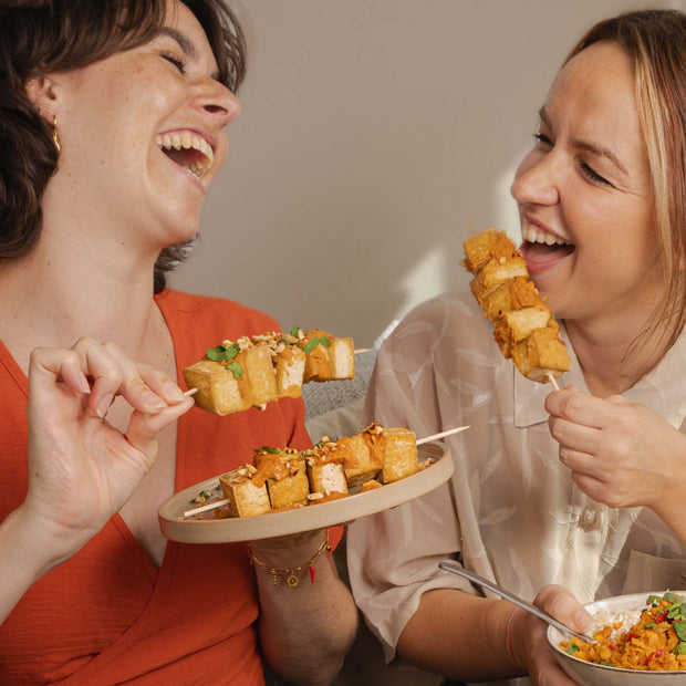 2 Frauen, die Tofu-Spiesse essen