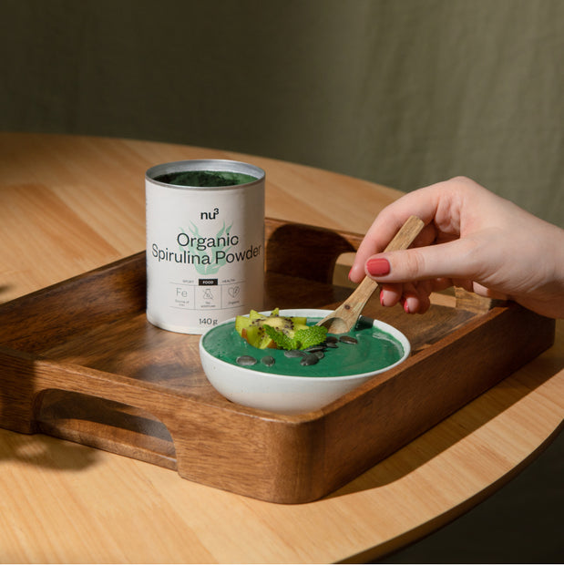 Hand rührt grüne Spirulina Mahlzeit