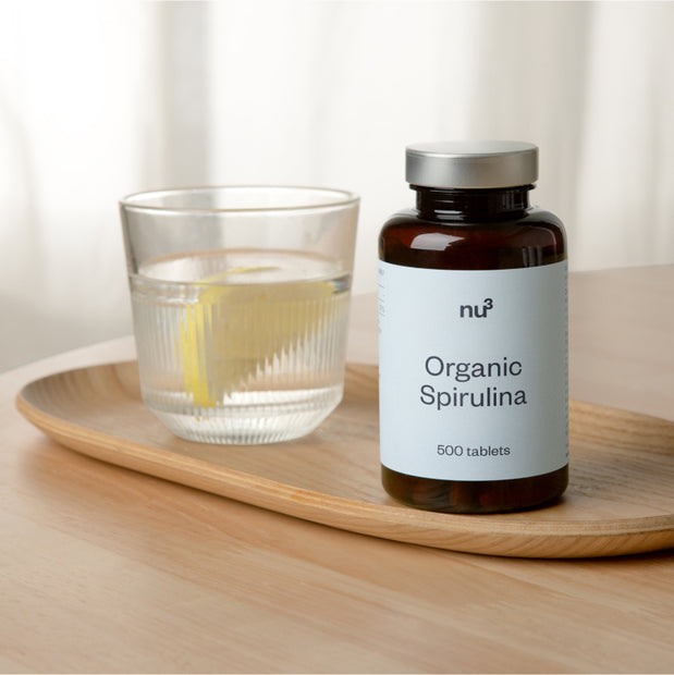 Glas neben Spirulina Tabletten Verpackung