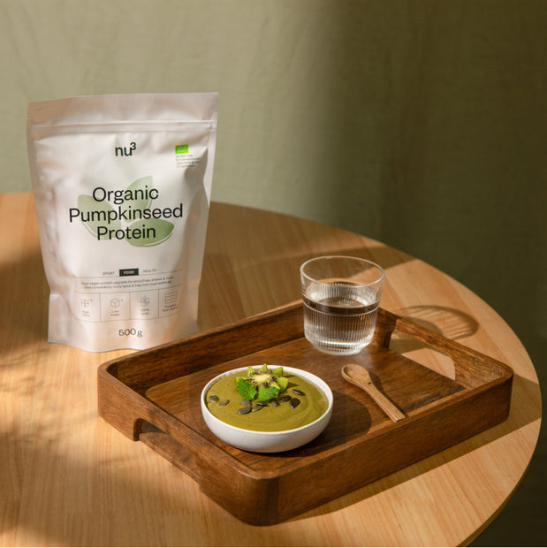 Eiweiss Bowl auf Tisch neben Kürbiskernprotein