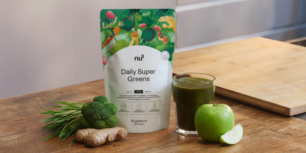 Greens mit Brokkoli, Apfel, Ingwer und einem Glas mit grünen Inhalt