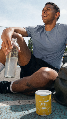 Sportlicher Mann trinkt aus Shaker