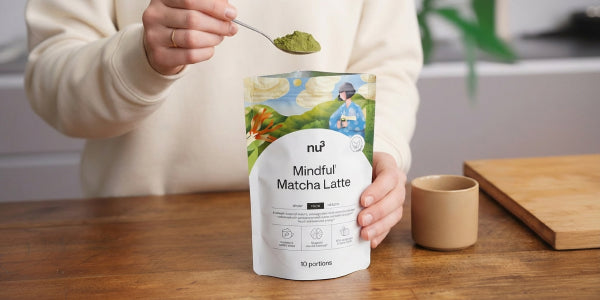 Pouch mit Matcha Instand-Latte, einem Löffel mit Pulver und einer Tasse