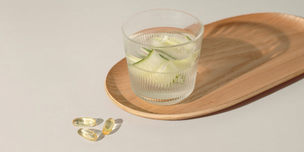 Vegane Omega-3-Kapseln und ein Glas Wasser